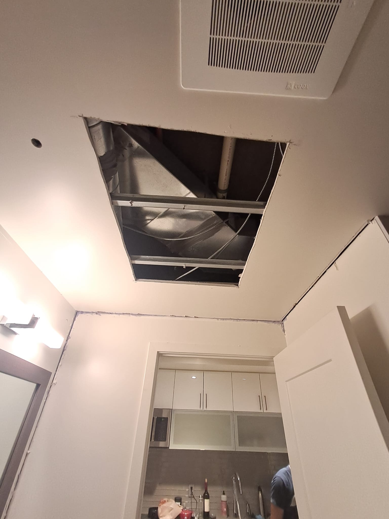 Bathroom ceiling cut open before drywall repair