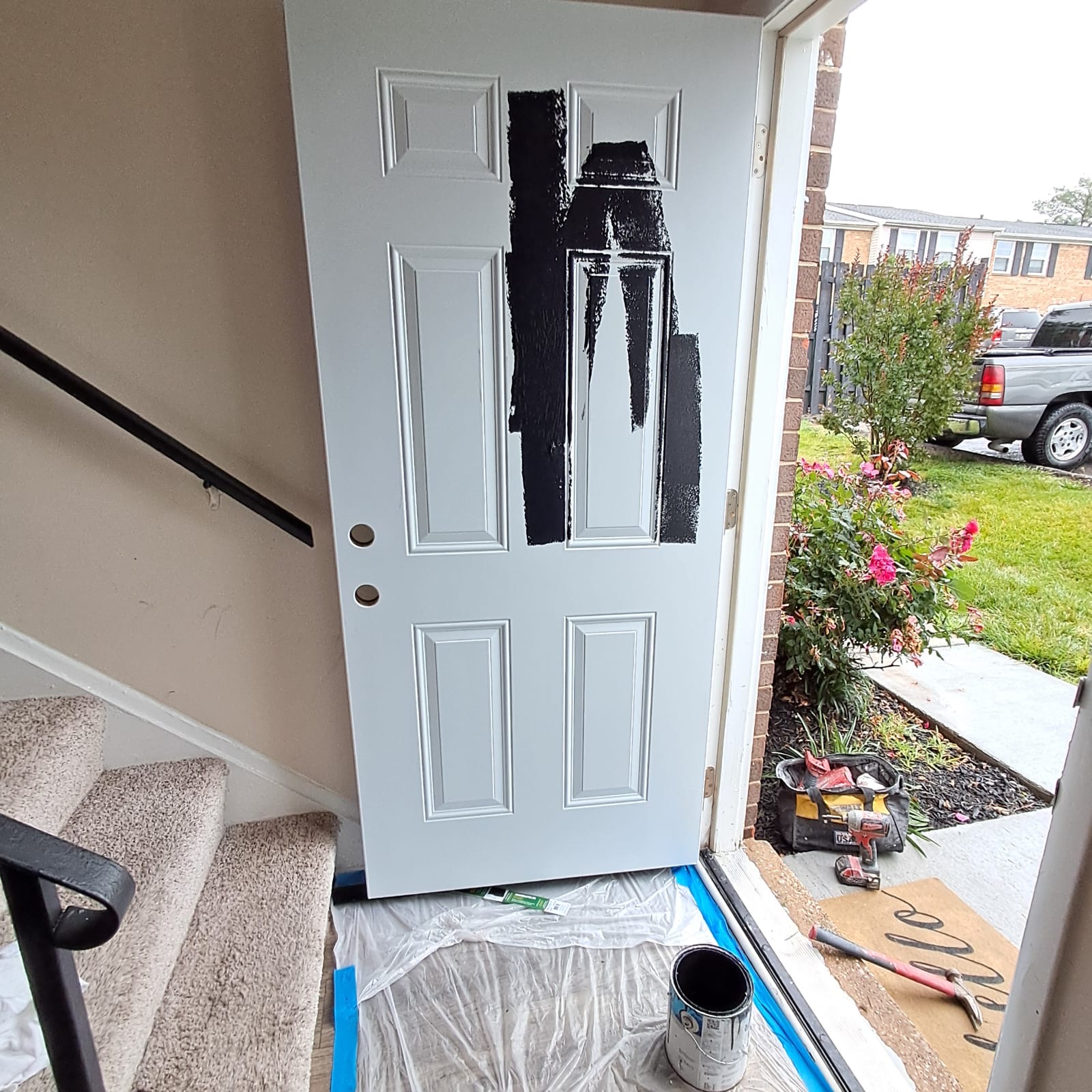 Entry door being painted black during the job